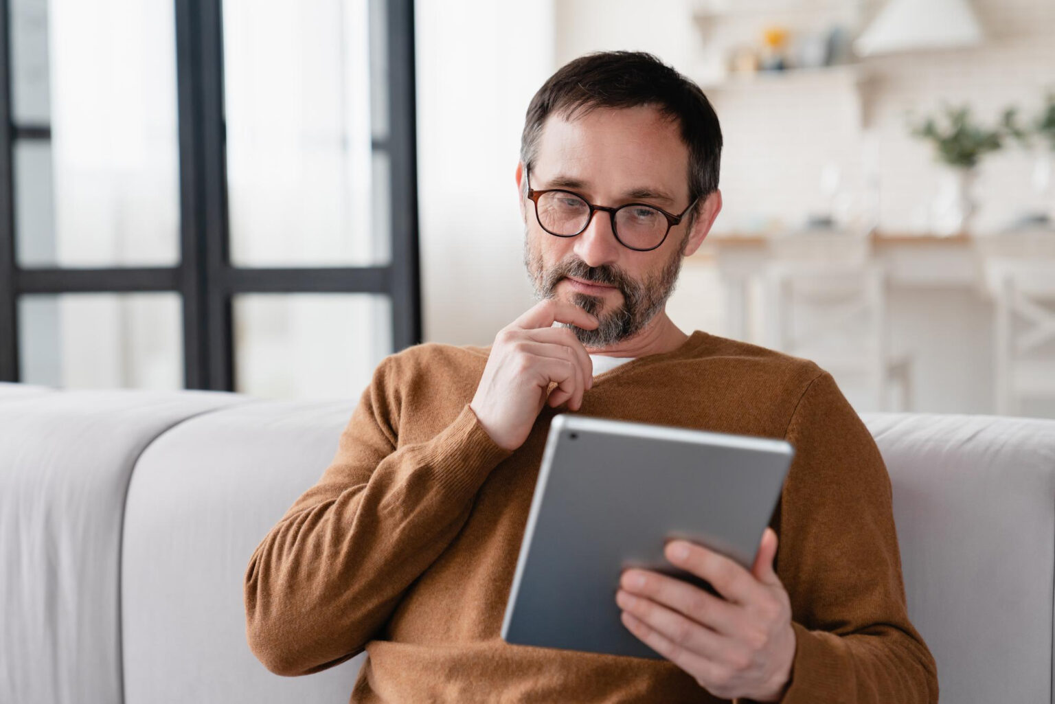 A web designer thinks about their graphic mockups on an iPad